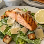 Salmon Caesar Salad served with crispy croutons, fresh Romaine lettuce, and grilled salmon.