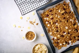 Delicious homemade protein granola with nuts, seeds, and dried fruits on a baking sheet, perfect for a healthy breakfast or snack.